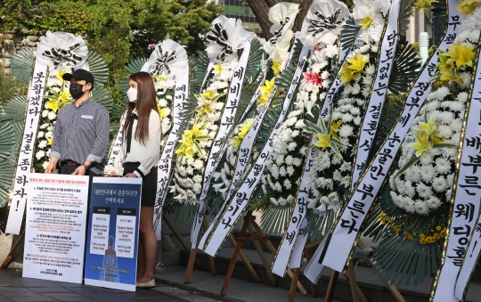 9일 오전 정부서울청사 앞에서 전국신혼부부연합회 회원들이 정부의 결혼식 방역 지침 개선을 요구하며 화환 시위를 하고 있다.  연합뉴스